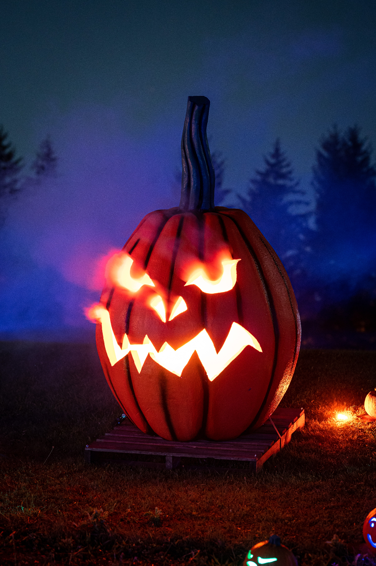 A large hand-carved jack-o'-lantern glowing at night